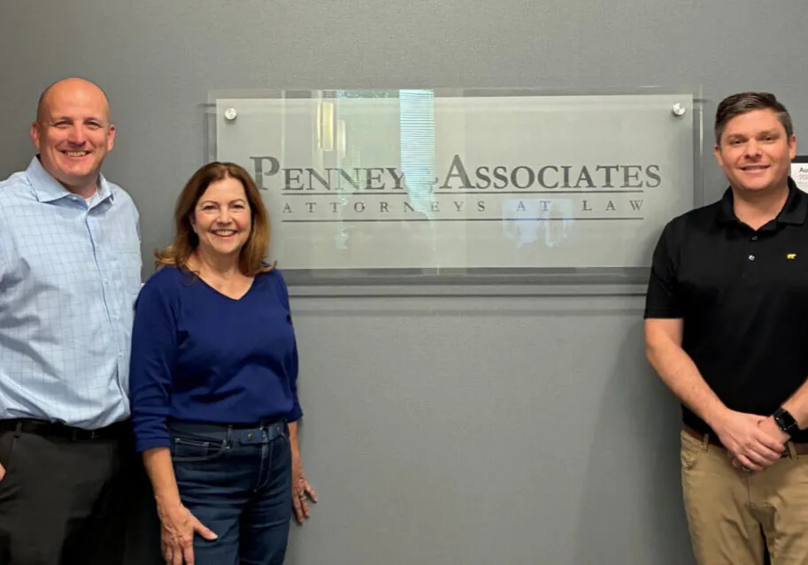 Miller-Hahn Client Photo Adam Hahn standing with a client next to the Penney & Associates office sign