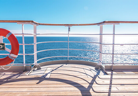 Image of cruise ship railing with a life preserver.
