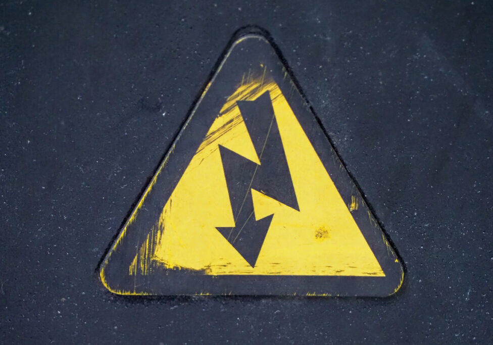 penney-assoc-electrical-injuries Image of a yellow electrical hazard sign with the standard downward facing lightning bolt