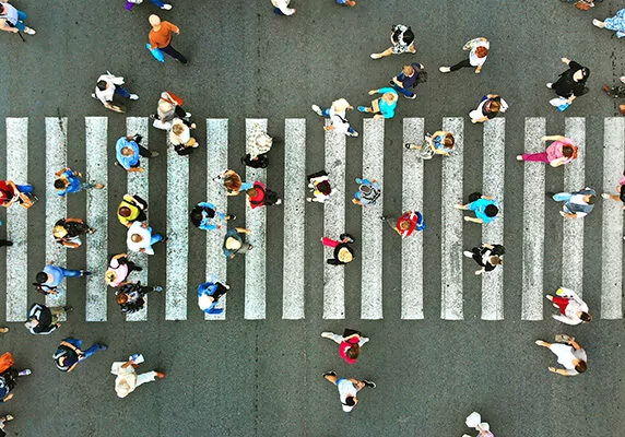 Pedestrians walking on and around a large crosswalk