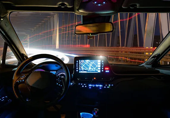 Long exposure image from the inside of a self driving car with map showing on inside console screen
