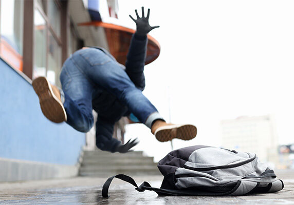 Person slipping on ground and dropping bag