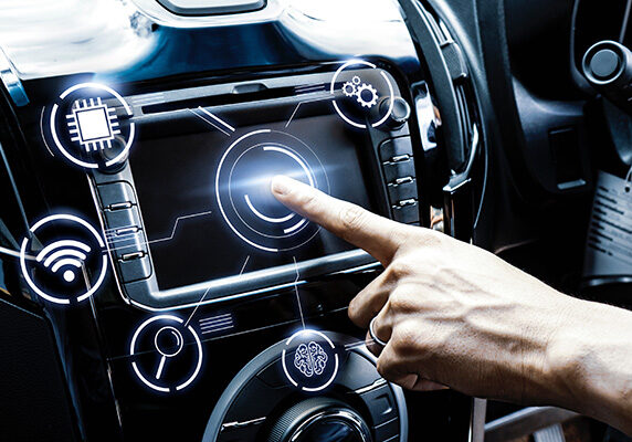Finger touching console screen in smart car with illustrations of WIFI, a lock, and a brain surrounding it